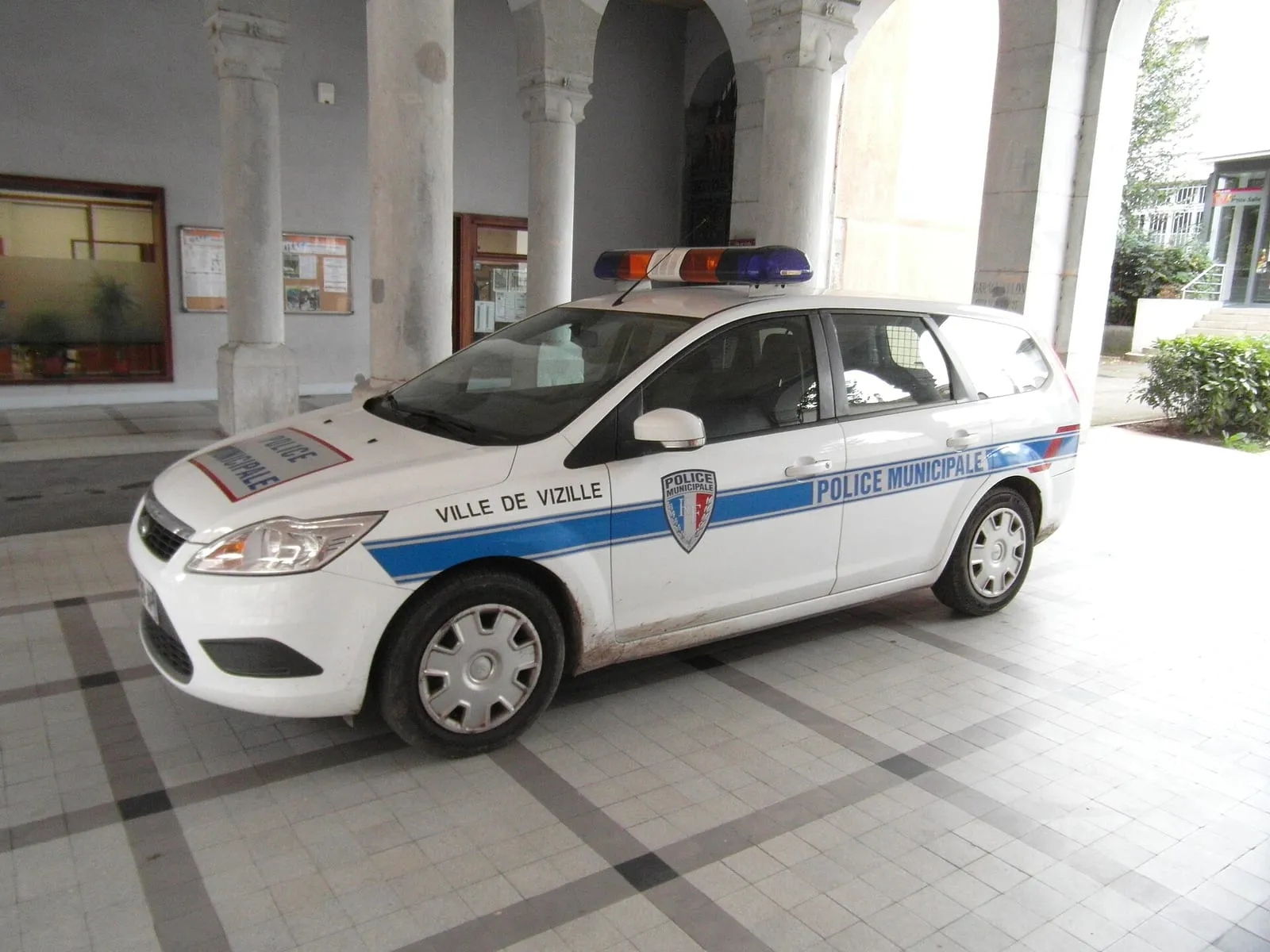 Une voiture de police municipale stationnée dans une rue