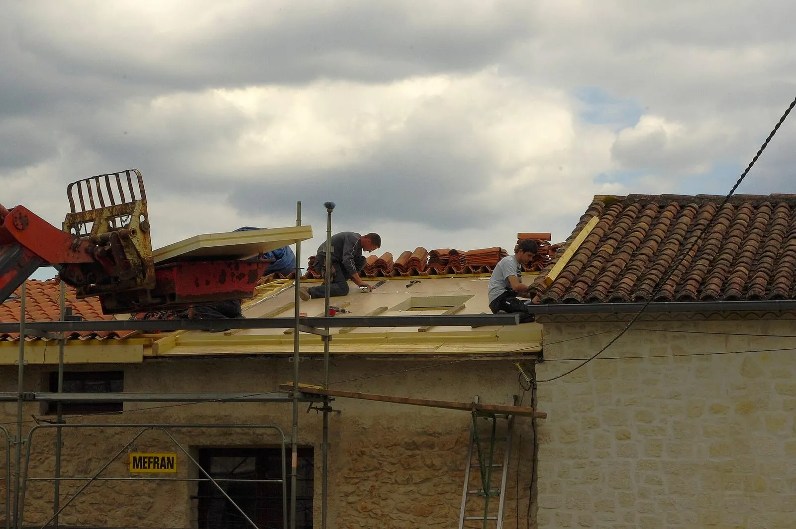 Couvreurs sur un toit en cours de rénovation