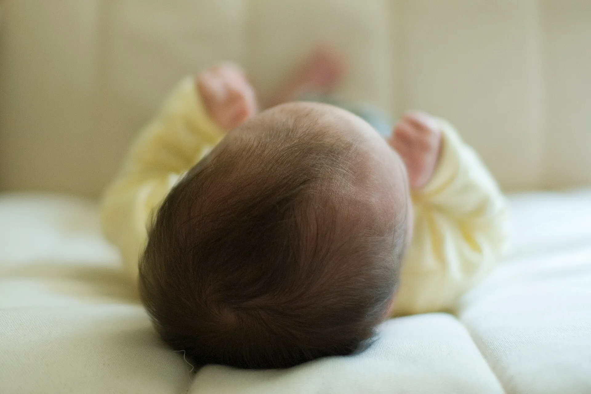 Un bébé endormi dans son lit à barreaux